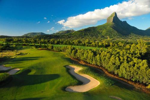 an aerial view of a golf course with a river and mountains at Appartement de luxe piscine et vue mer in Rivière Noire