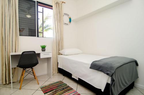Schlafzimmer mit einem Bett, einem Schreibtisch und einem Stuhl in der Unterkunft Conforto e Estilo no Centrinho da Lagoa QX6398 in Florianópolis