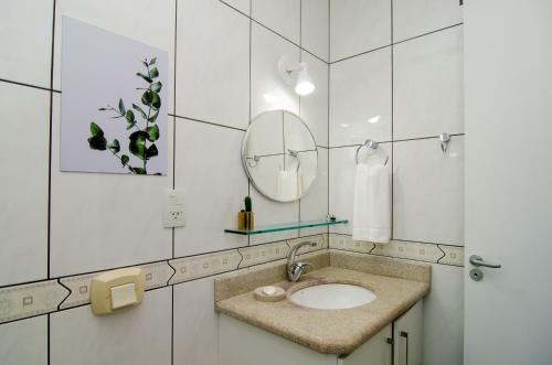 ein Bad mit einem Waschbecken und einem Spiegel in der Unterkunft Conforto e Estilo no Centrinho da Lagoa QX6398 in Florianópolis