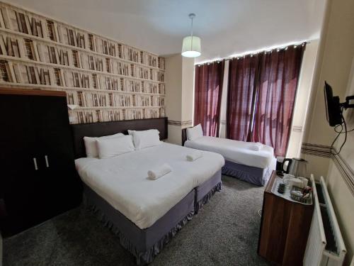 ポーツマスにあるPortsmouth Budget Hotels - All rooms are EN-SUITEのベッド2台と窓が備わるホテルルームです。