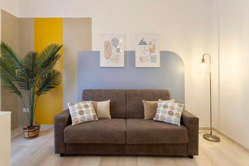 a living room with a brown couch with two pillows at Elide - Love Locks in Ponte Milvio in Rome