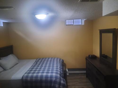 a bedroom with a bed and a dresser and a mirror at One bedroom basement suite with private living room and laundry. in Brampton