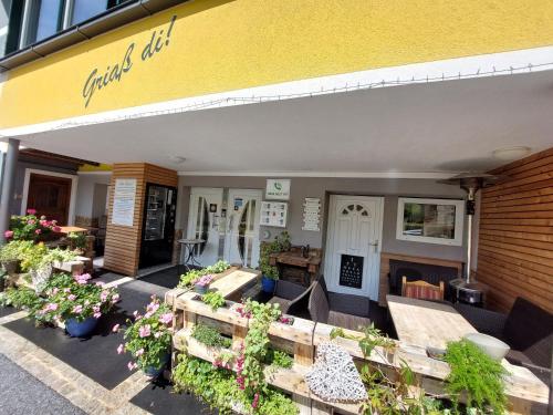 a store front with plants and flowers on a patio at Gasthof Klug zum Ehrensepp in Modriach