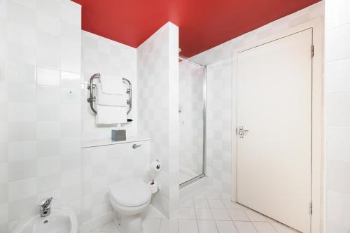 a white bathroom with a toilet and a shower at Holiday Inn Leeds Brighouse by IHG in Brighouse