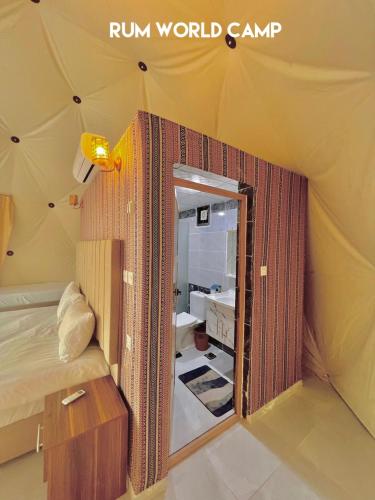 Habitación con cama y espejo en una tienda. en Rum world camp, en Wadi Rum
