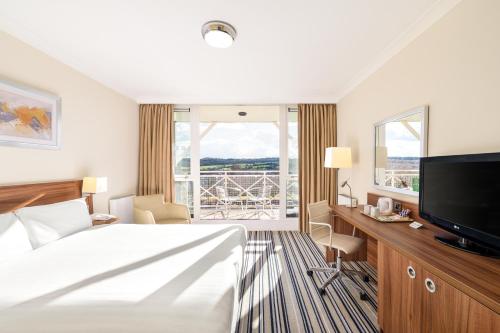 a hotel room with a bed and a flat screen tv at Holiday Inn Leeds Brighouse by IHG in Brighouse