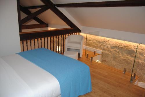 a bedroom with a bed and a chair in a room at Gaia Loves You - Ponte D. Luis in Vila Nova de Gaia