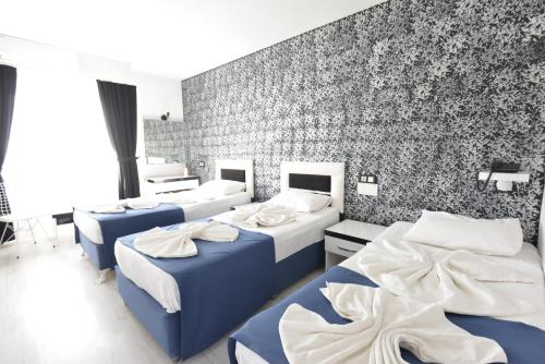 a room with four beds and a brick wall at La Rezidans Hotel in Antalya