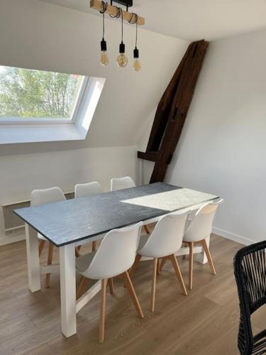 une salle à manger avec une table et des chaises blanches dans l'établissement Logis du Coudray, à Saint-Philbert-sur-Boissey