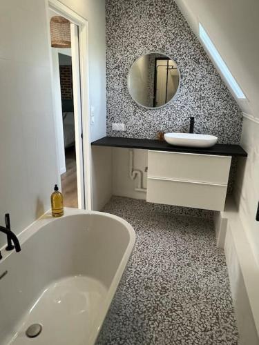 une salle de bain avec une baignoire, un lavabo et un miroir dans l'établissement Logis du Coudray, à Saint-Philbert-sur-Boissey