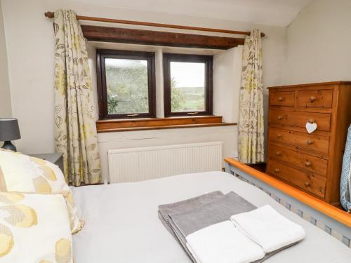 a bedroom with a bed and a window at Moorside Cottage in Oxenhope