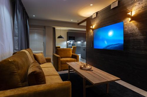 - un salon avec un canapé et une télévision murale dans l'établissement Royal Roi Apartments, à Rovaniemi