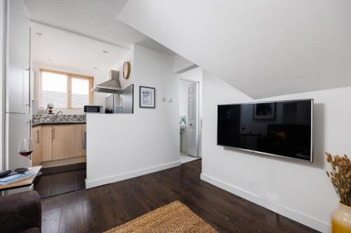 a living room with a large flat screen tv on a wall at Central Plymouth 1 Bedroom Apartment - Sleeps 5 - Habita Property in Plymouth