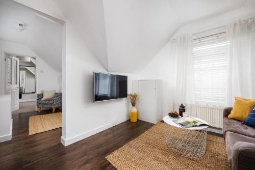 a living room with a couch and a tv on a wall at Central Plymouth 1 Bedroom Apartment - Sleeps 5 - Habita Property in Plymouth