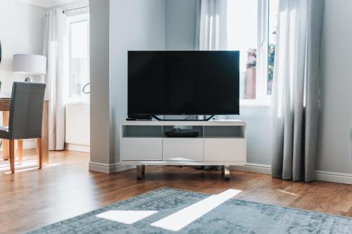 a living room with a flat screen tv on a white cabinet at Stylish spacious home in Redcar in Redcar