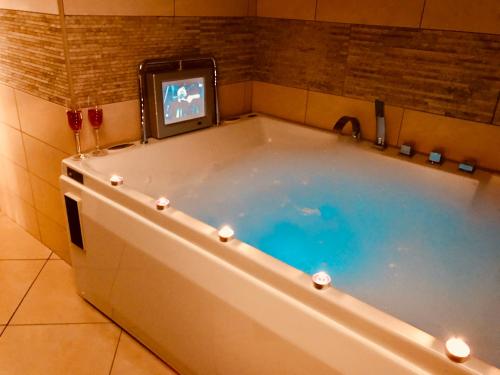 a bath tub with a tv in a bathroom at Centrum Panzió in Szentendre