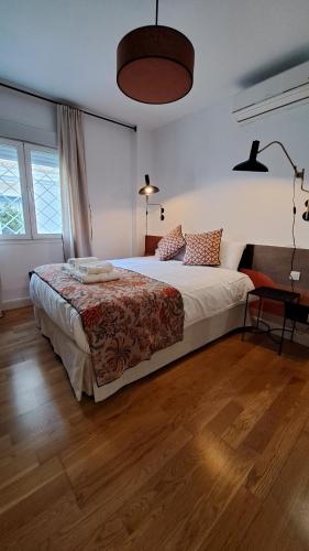 1 dormitorio con 1 cama grande y suelo de madera en DreamsApt San Eloy, en Sevilla