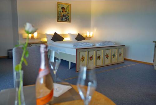 Habitación con cama y mesa con botella de vino en Villa Bello en Berchtesgaden