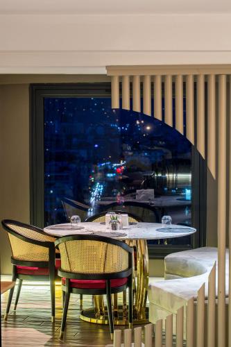 a dining room with a table and chairs and a window at DoubleTree by Hilton Izmir - Alsancak in Izmir