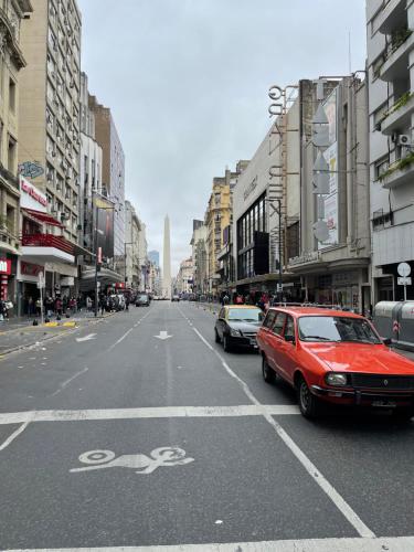 un coche rojo está aparcado en una calle de la ciudad en APART OBELISCO en Buenos Aires