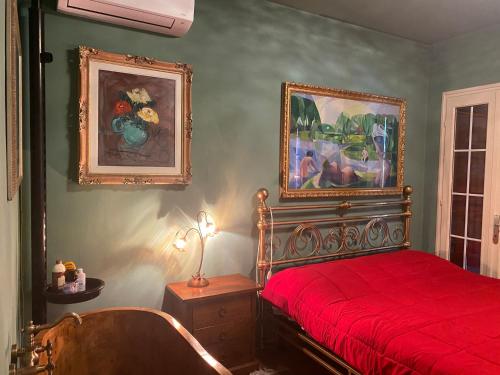 Un dormitorio con una cama roja y una pintura en la pared en B&B Al Casel, en Tovena