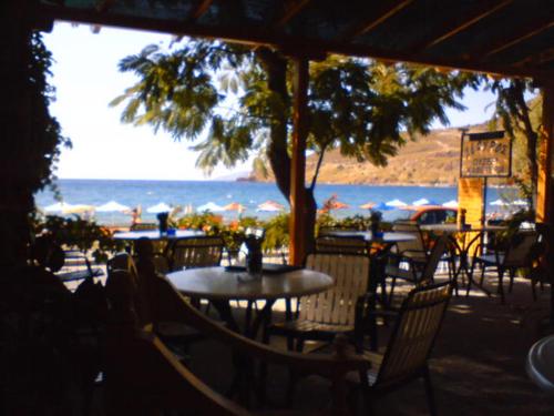 an outdoor patio with tables and chairs and the ocean at Dimitra in Petra
