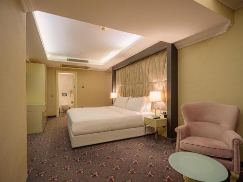 a hotel room with a bed and a chair at DoubleTree by Hilton Izmir - Alsancak in Izmir