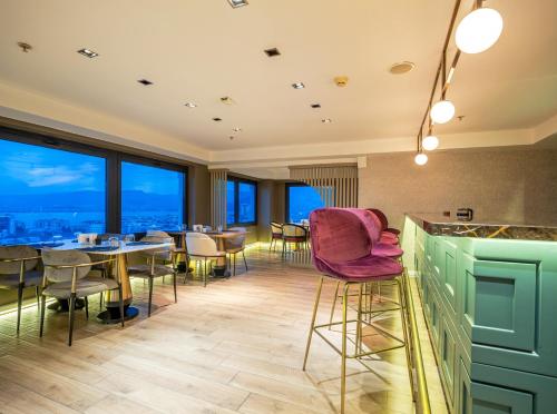 a restaurant with tables and chairs and large windows at DoubleTree by Hilton Izmir - Alsancak in Izmir