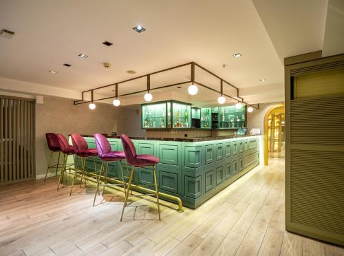 a bar with red chairs and a green counter at DoubleTree by Hilton Izmir - Alsancak in Izmir