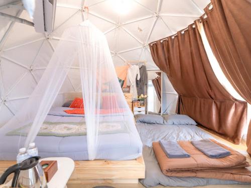 a bedroom with a bed in a tent at Phu Morinn Cafe &Camping Monjam in Mon Jam