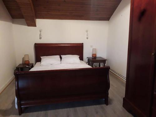 une chambre avec un grand lit avec deux tables de nuit dans l'établissement Les guernouilles, à Mézières-en-Brenne