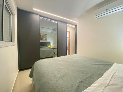 a bedroom with a large bed and a mirror at Elegante apto de 2/4 2004 in Goiânia
