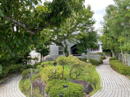 a walkway in front of a house with a garden at 伊豆RONG in Ito