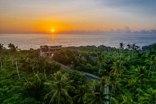 a sunset over the ocean with palm trees at Izustarri in Burgos