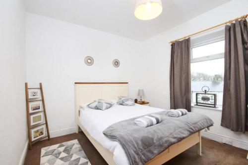 a white bedroom with a bed and a window at The Comfortable Cottage of The Dales - Sleeps 5 in Skipton