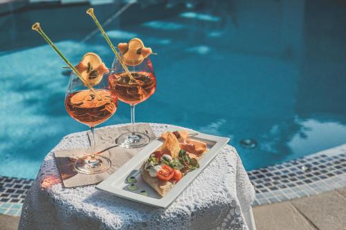 einen Teller mit Essen auf einem Tisch mit zwei Gläsern Wein in der Unterkunft Adults only Hotel Grafenstein in Schenna