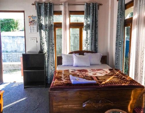 a bedroom with a wooden bed with a window at Abhinay Natural Homestay by StayApart in Gorubathān