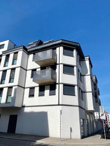 a white building with black windows on a street at Vienna´s Danube Apartments in Vienna