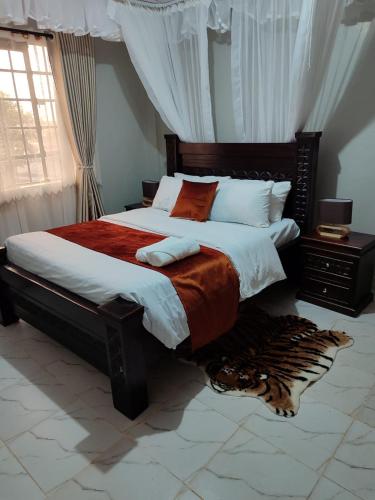 ein Schlafzimmer mit einem großen Bett mit einer roten Decke in der Unterkunft The Nest Githunguri in Kamondo