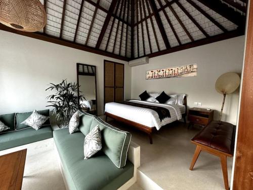 a bedroom with a bed and a couch in a room at Di Cappio Villa Uluwatu 1 in Uluwatu