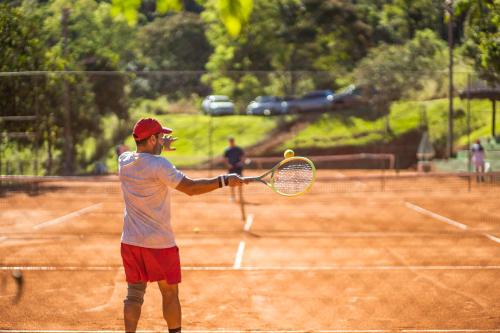 a man hitting a tennis ball with a racket at Itá Thermas Resort e Spa in Itá