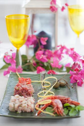 a table with a plate of food and a glass of wine at Quartara Boutique Hotel in Panarea