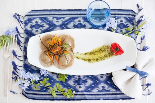 a plate of food on a table with a glass of wine at Quartara Boutique Hotel in Panarea