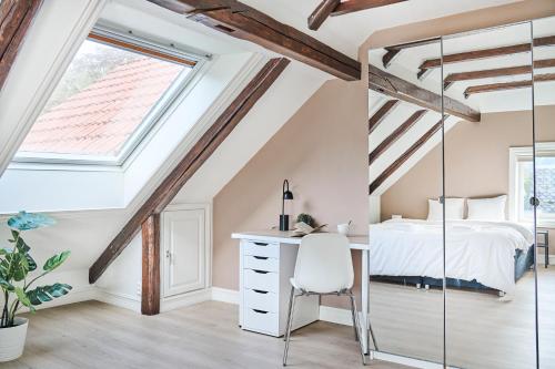 a bedroom with a bed and a desk in a attic at Queen's Cave By Staysville in Stavanger