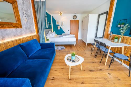 a living room with a blue couch and a table at Appartement Stelo Gosau-Hallstatt in Gosau