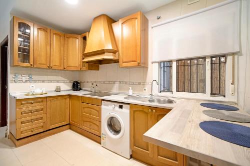 a kitchen with wooden cabinets and a washing machine at Casa Fluri in San Fernando