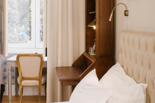 a bedroom with a bed and a chair and a window at Alegria A Lisbon Boutique Hotel in Lisbon