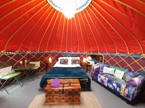 Habitación con cama y sofá en una yurta en Orchard View Yurt & Hot Tub Somerset en Weston-super-Mare