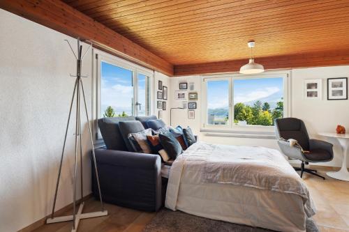 Luxus Loft am Zürichsee I Seesicht I Garten I Arbeitsplatz في Richterswil: غرفة نوم بسرير وكرسيين ونافذة