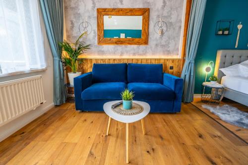 a living room with a blue couch and a table at Appartement Stelo Gosau-Hallstatt in Gosau